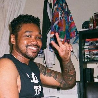 person simling and throwing up a peace sign